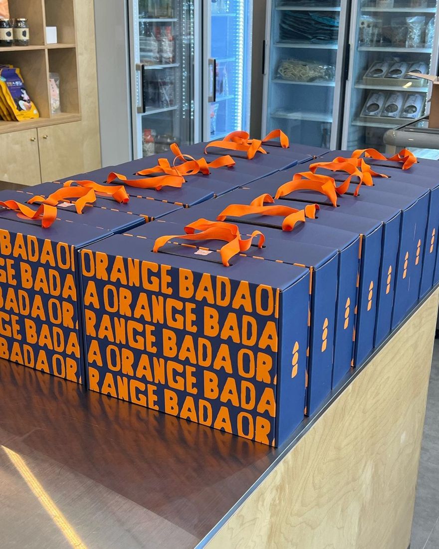 2023 — 남색 「ORANGE BADA」 반복 패턴 상자 + 주황 리본